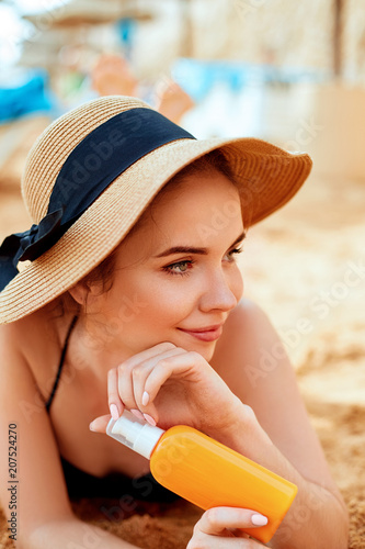  Sexy Young Woman in Bikini  Holding  Bottles of Sunscreen in Her Hands. Skincare. A Female  Applying Sun Cream Creme.Sun protection