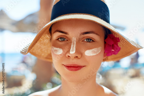 Suntan Lotion Woman Applying Sunscreen. Female smear  sun cream  on face. SkinCare.