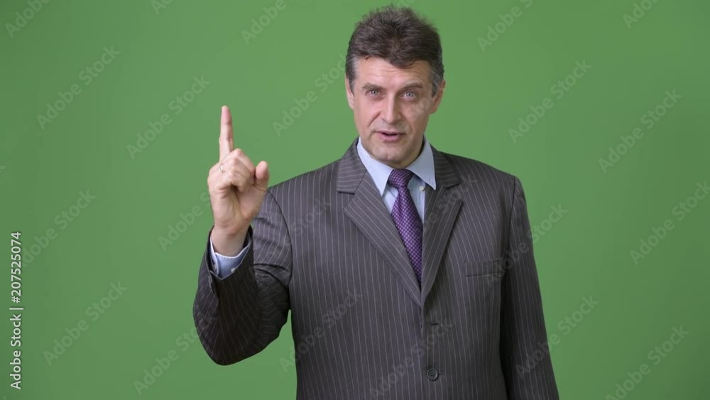 Mature handsome businessman against green background Mature handsome businessman against green background