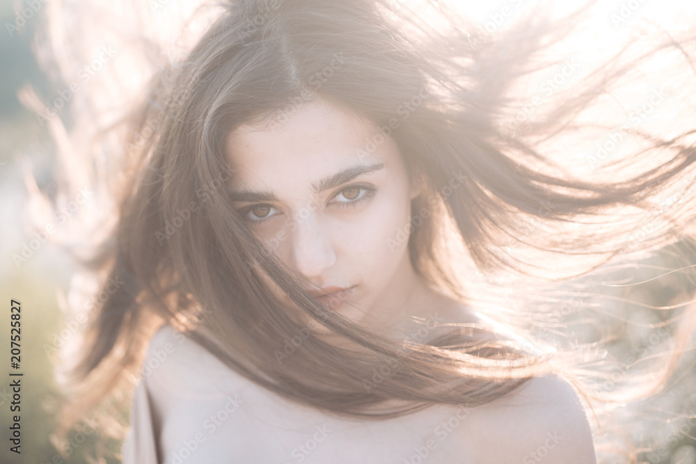 Girl with nude shoulders enjoy her hair waving by wind. Hair care concept.Woman on calm face enjoy sunny and windy day, nature on background, defocused. Lady looks attractive with waving long hair Girl with nude shoulders enjoy her hair waving by wind. Hair care concept.Woman on calm face enjoy sunny and windy day, nature on background, defocused. Lady looks attractive with waving long hair