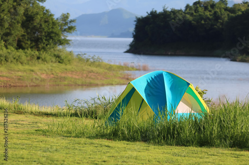 Campsite and tents on the lawn with beautiful green nature landscapes of dam water