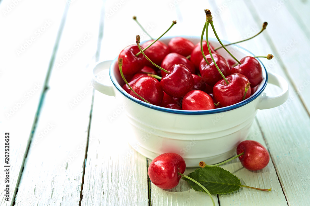 Dish of healthy red cherries on a picnic table Dish of healthy red cherries on a picnic table