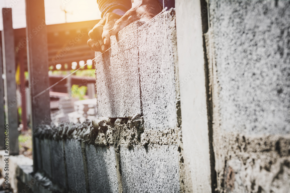 Worker with block concrete cement mortar wall at construction site. Worker with block concrete cement mortar wall at construction site.