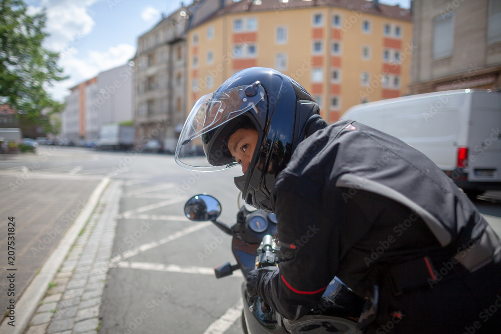 Woman with a black helmet on a motorbike