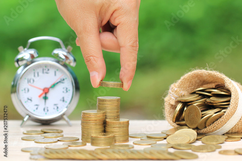Save money for prepare in future concept, Hand of the female putting money coin into the bag on natural green background photo