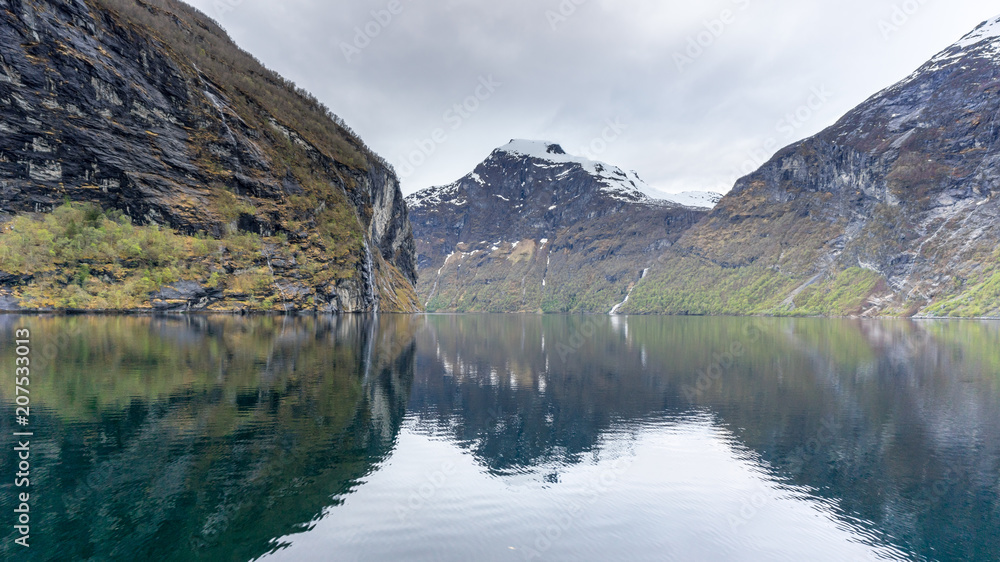 Reflection of mountains in the water in Geirangerfjord, Norway