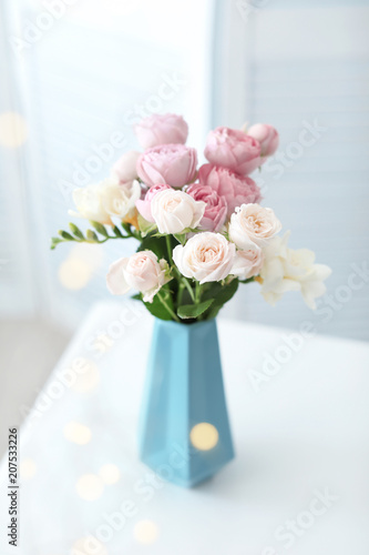 Vase with beautiful flowers on table indoors © New Africa