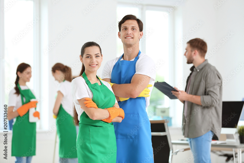 Team of professional janitors in uniform indoors Team of professional janitors in uniform indoors