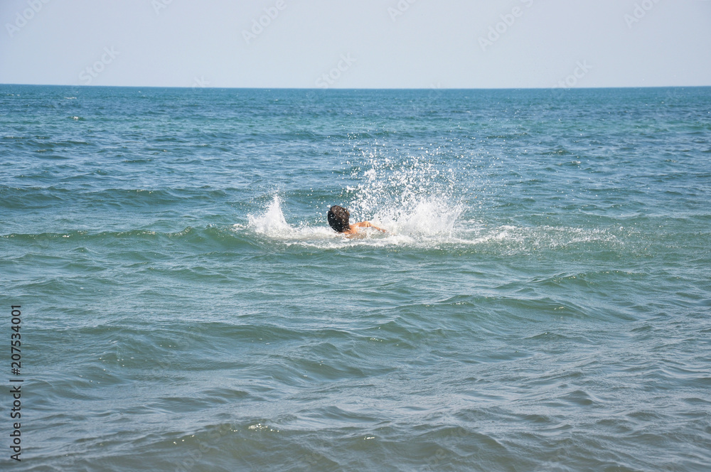 A drowning man. Sticking out of the ocean hands. Sinking human in the sea. Dangerous swimming in the blue water A drowning man. Sticking out of the ocean hands. Sinking human in the sea. Dangerous swimming in the blue water
