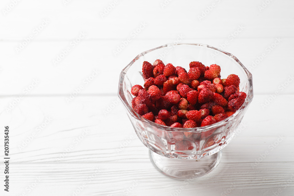 Fresh strawberry fruit in a glass dish on a white background. Free space. Fresh strawberry fruit in a glass dish on a white background. Free space.