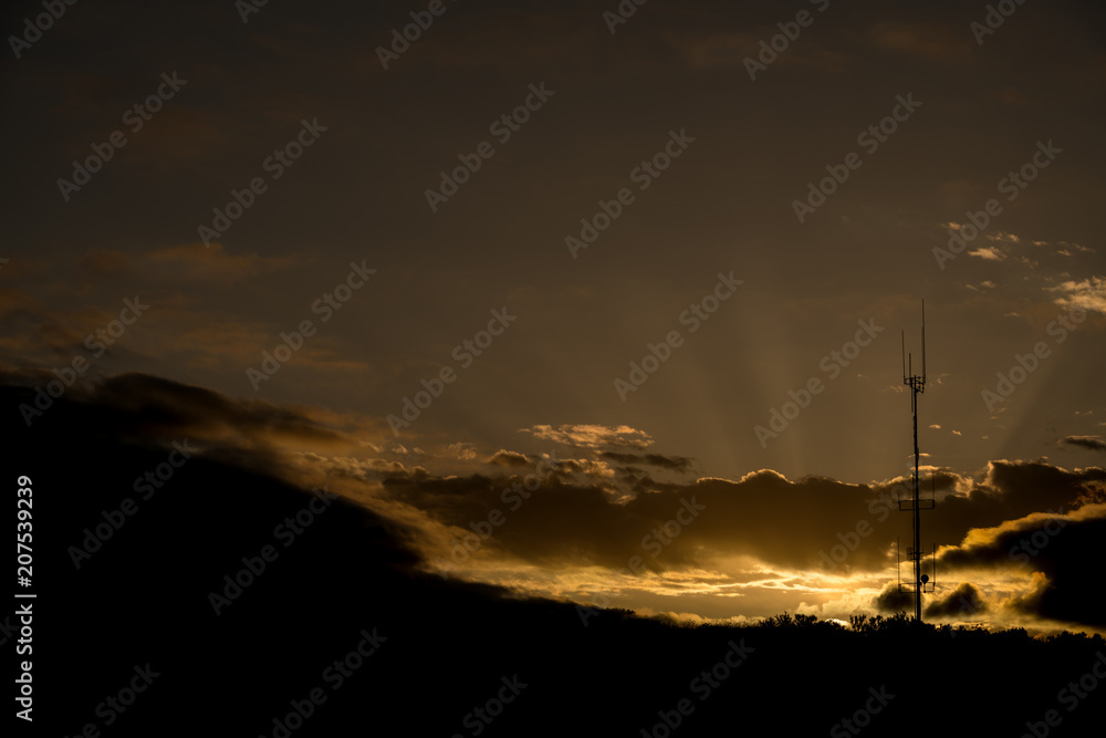 Broadcast antenna silhouette with dramatic sunrise behind