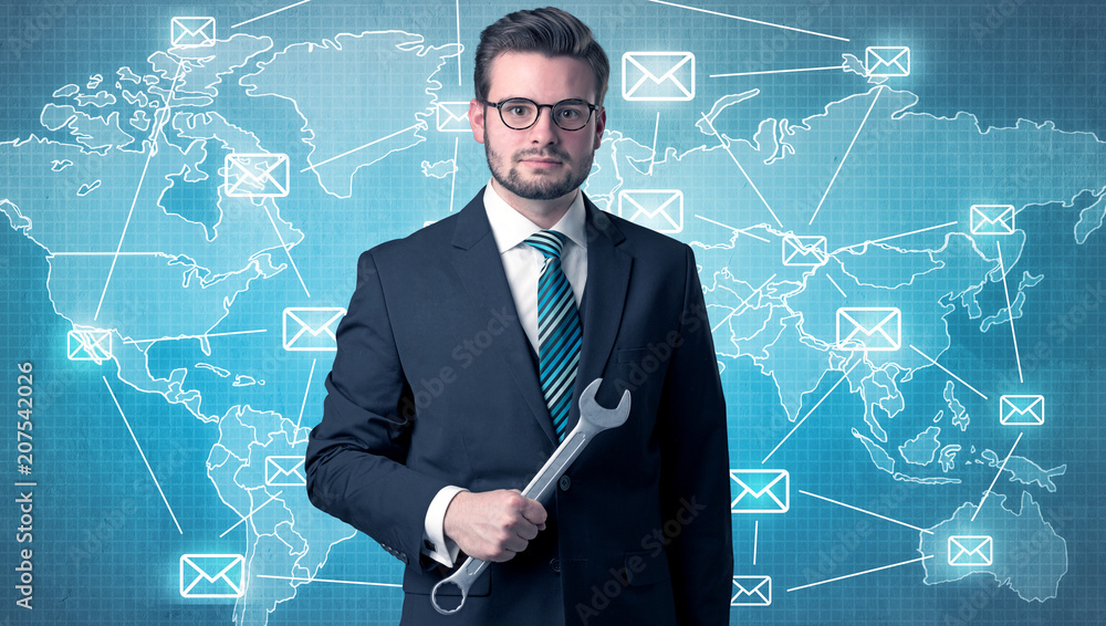 Businessman holding tool with global map graphic on the background Businessman holding tool with global map graphic on the background