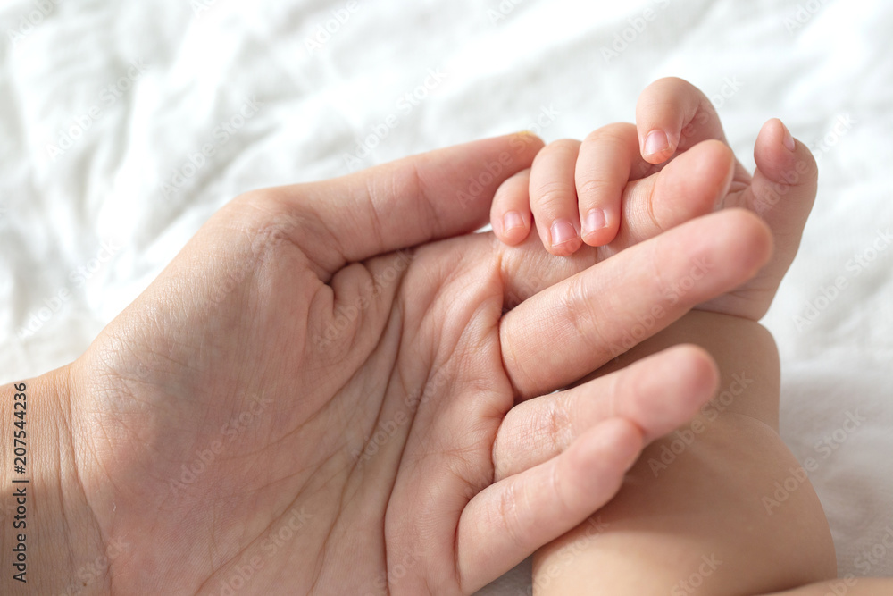 Baby uses his tiny fingers to hold his mother's finger to make him feeling her love, warm, comfort and secure. Baby uses his tiny fingers to hold his mother's finger to make him feeling her love, warm, comfort and secure.