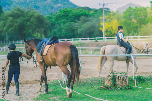The female trainer is training the young horse for the tame in r © JinnaritT