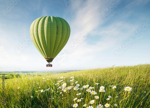 Air ballon above field with flowers at the summer time. Concept and idea of adventure