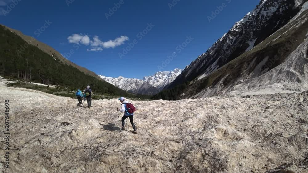 Hikers are walking on the snow in the mountains Hikers are walking on the snow in the mountains