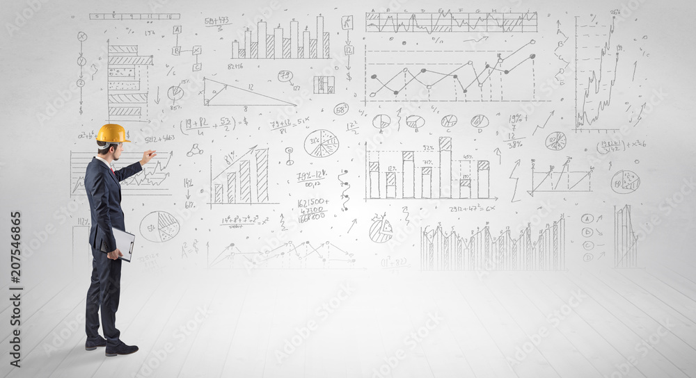 Engineer with construction helmet holding a plan and standing with graphs, charts and reports on the background Engineer with construction helmet holding a plan and standing with graphs, charts and reports on the background