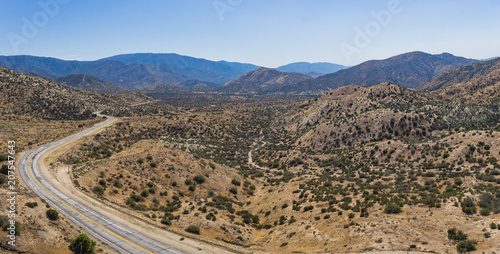 Panorama of vast desert wilderness and curving highway road through the emptiness. photo