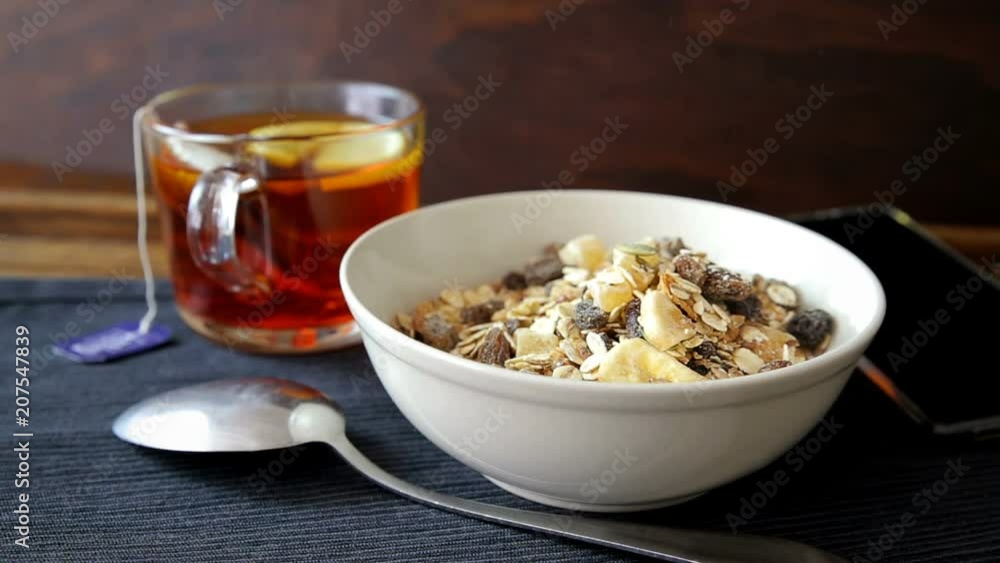 Preparing muesli and milk breakfast. Cup of tea with lemon. Preparing muesli and milk breakfast. Cup of tea with lemon.