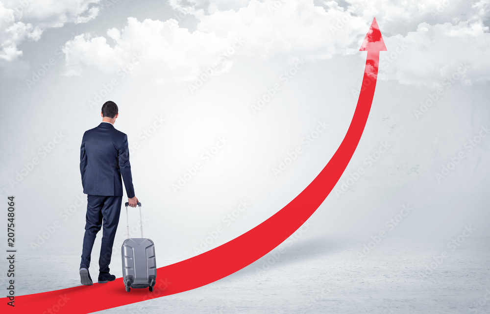 Young businessman with back leaving on the red arrow carpet to the skies with luggage on his hand
Young businessman with back leaving on the red arrow carpet to the skies with luggage on his hand