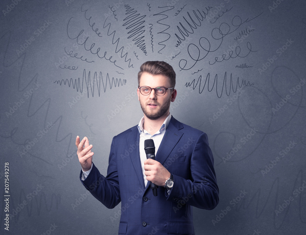 Businessman speaking into microphone with scribbles over his head Businessman speaking into microphone with scribbles over his head