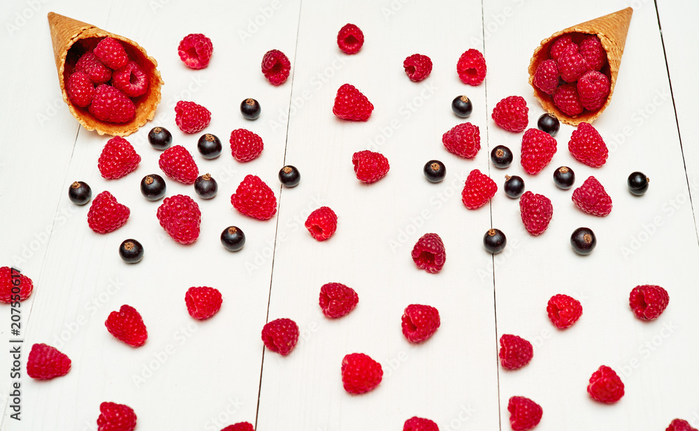 Top view of sweet fresh organic raspberries and black currants in ice cream waffle cone. Fresh berries in cone on white wooden background. Summer and healthy food concept. Berries background Top view of sweet fresh organic raspberries and black currants in ice cream waffle cone. Fresh berries in cone on white wooden background. Summer and healthy food concept. Berries background