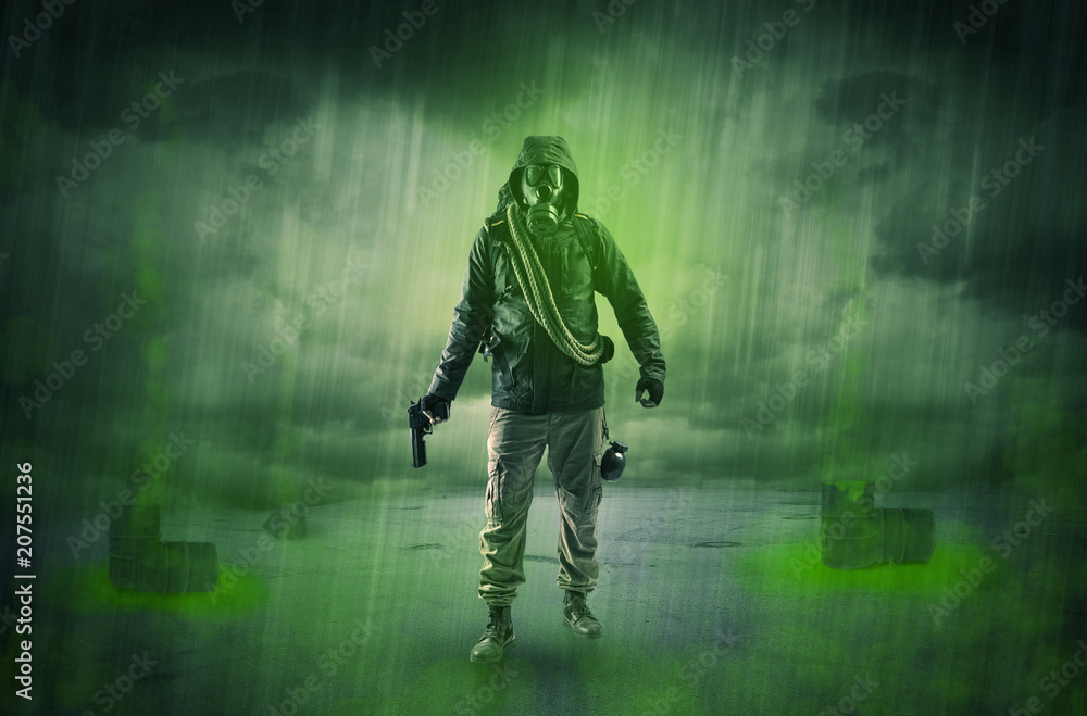 Fototapeta premium Masked unrecognizable guard in an abandoned space after explosion 