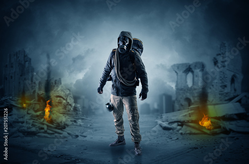 Destroyed place after a catastrophe with man in gas mask and weapon on his hand 