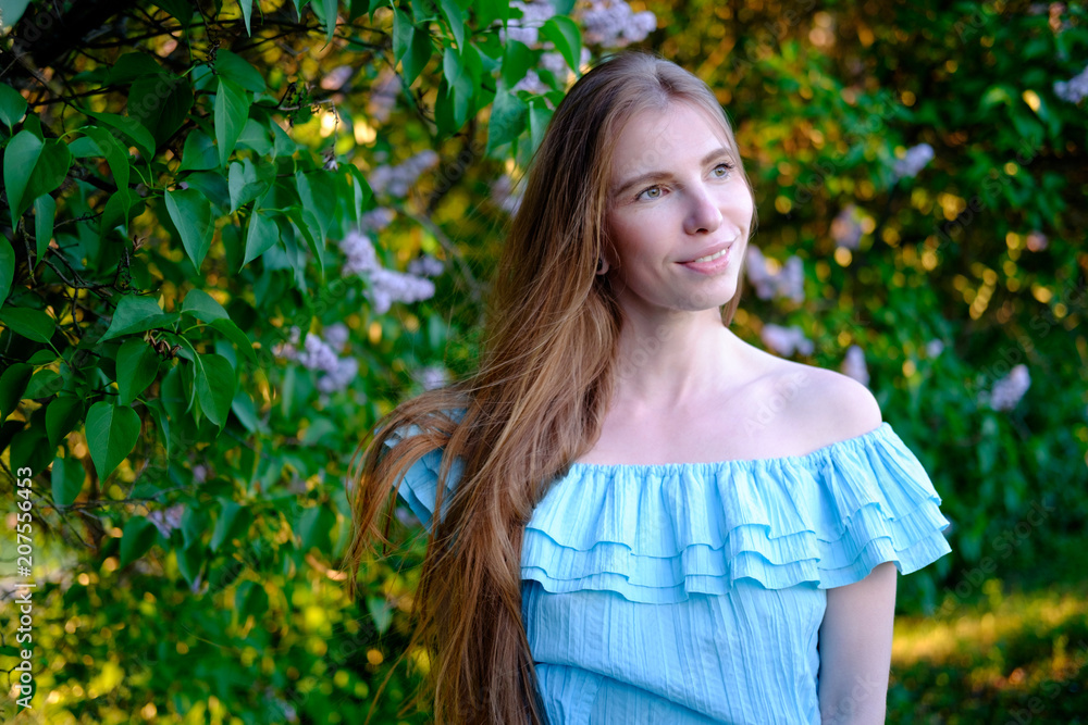 redhead girl in blue light cocktail dress in lilac bushes redhead girl in blue light cocktail dress in lilac bushes