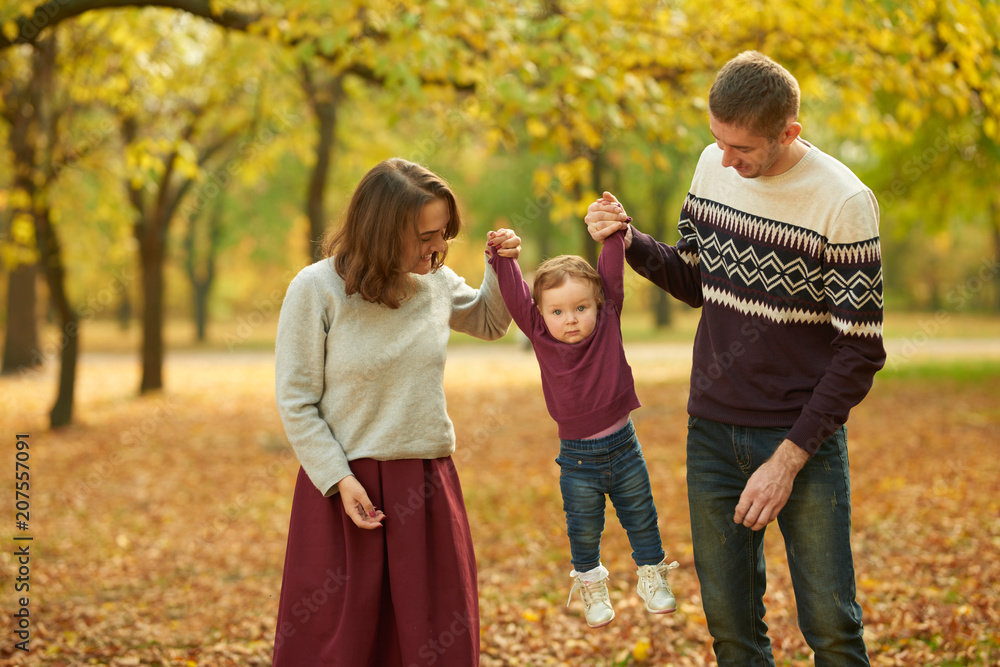 Cheerful family in an autumn park. Concept of rest and walk Cheerful family in an autumn park. Concept of rest and walk