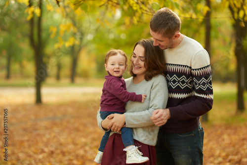 Cheerful family in an autumn park. Concept of rest and walk