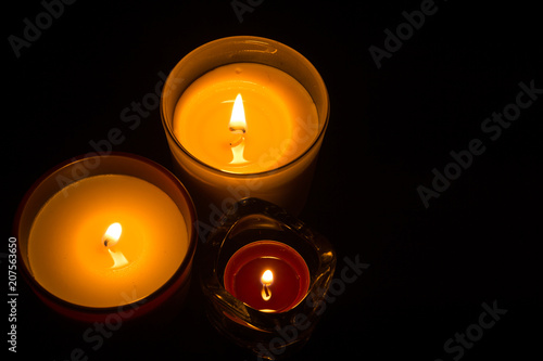 Three candles over black backdrop