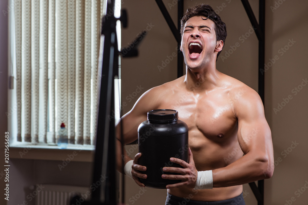 Man with nutrient supplements in sports gym Man with nutrient supplements in sports gym