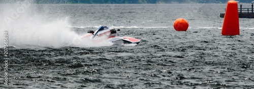 фотографія Red and white hydroplane racing boat on river heading towards orange bouys