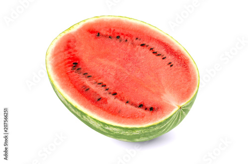 Sweet watermelon half, front view, on white background. Large ripe fruit of Citrullus lanatus with green striped skin, red pulp and black seeds. Edible, raw and organic. Food photo, closeup.
