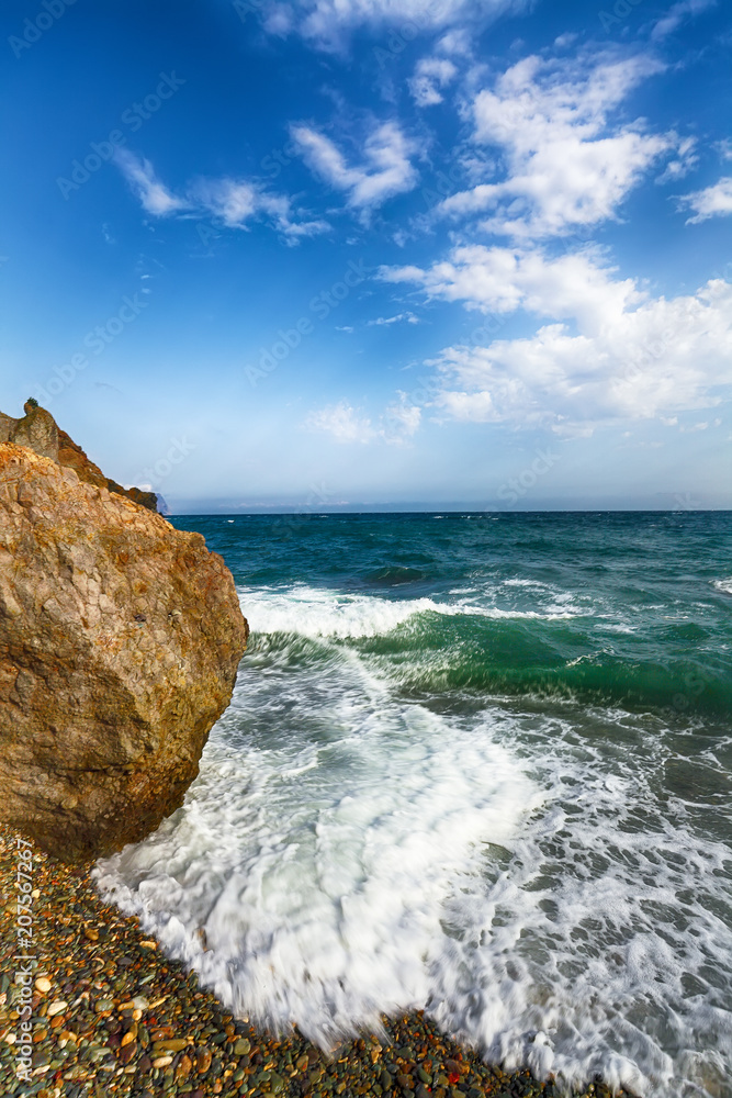 Sea waves crashing on the shore and flowing above seashore pebbles Sea waves crashing on the shore and flowing above seashore pebbles