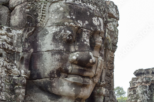 Stone face relief of ancient buddhist temple Bayon in Angkor Wat complex, Cambodia. Sightseeing in Cambodia