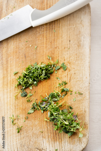 Chopped thyme on wooden board with knife 