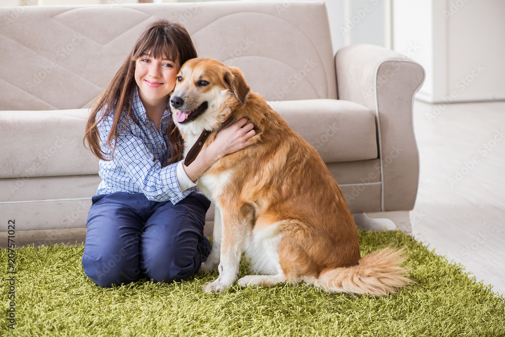 Happy woman dog owner at home with golden retriever Happy woman dog owner at home with golden retriever
