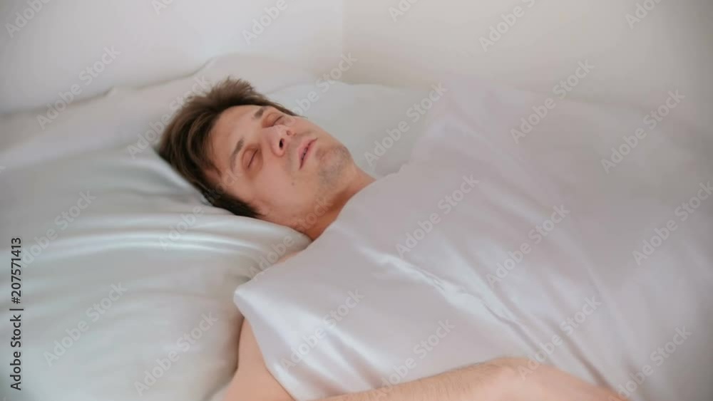 Man is sleeping in bed alone covered the blanket. Front view. Man is sleeping in bed alone covered the blanket. Front view.