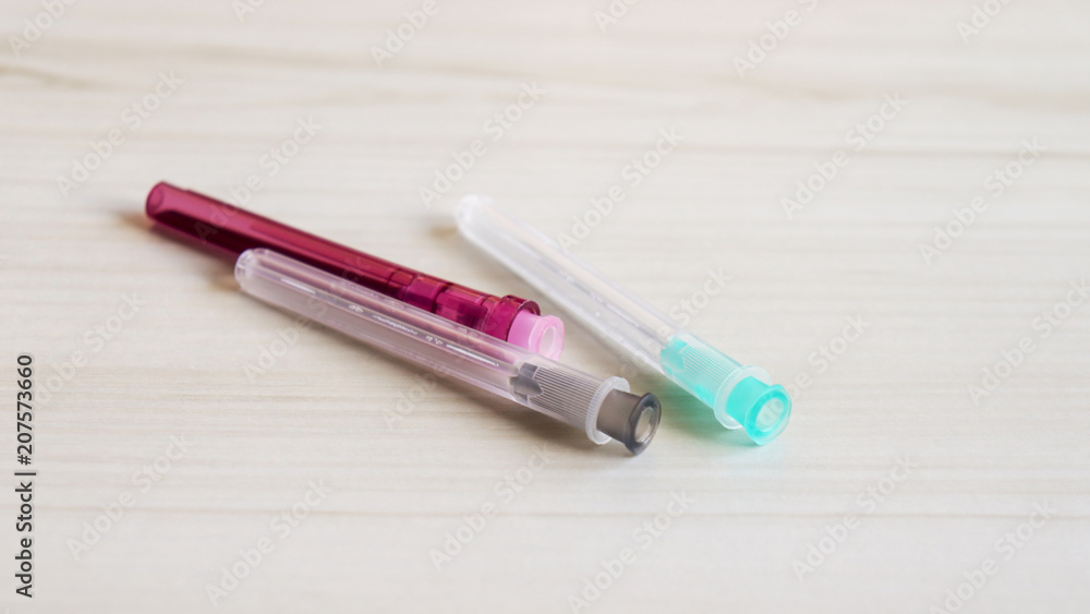 Three disposable syringe needles on the table. Three disposable syringe needles on the table.