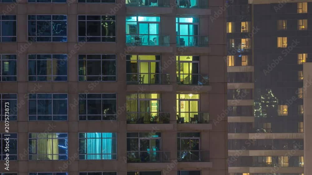 Windows of the multi-storey building of glass and steel lighting inside and moving people within timelapse Windows of the multi-storey building of glass and steel lighting inside and moving people within timelapse