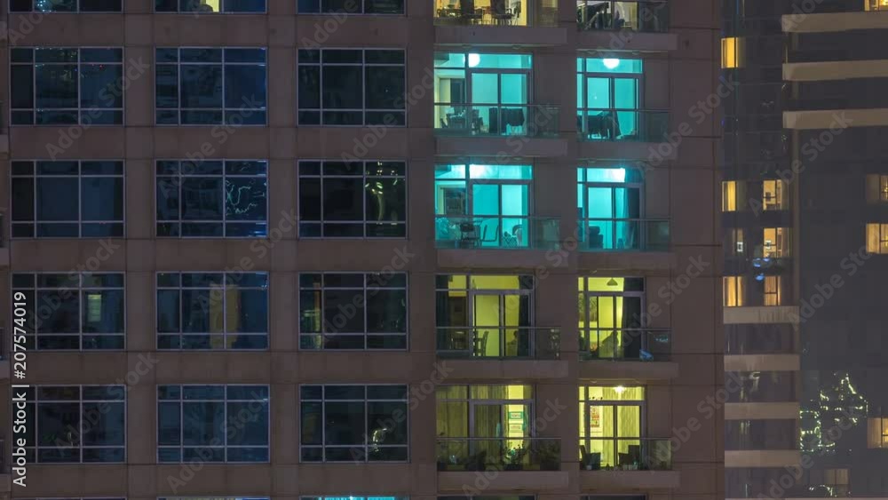 Windows of the multi-storey building of glass and steel lighting inside and moving people within timelapse Windows of the multi-storey building of glass and steel lighting inside and moving people within timelapse