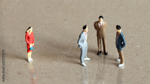 Tablou pe pânză One miniature woman standing apart from a group of three miniature men