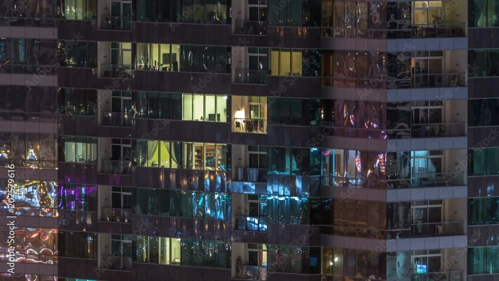 Windows of the multi-storey building of glass and steel lighting inside and moving people within timelapse Windows of the multi-storey building of glass and steel lighting inside and moving people within timelapse