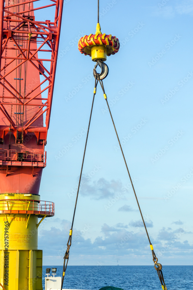 Fototapeta premium Offshore crane on a construction barge performing lifting activities