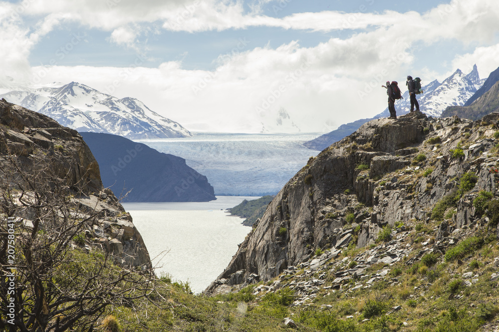 two men with backpacks on their backs watching the Gray glacier from a lookout during trekking