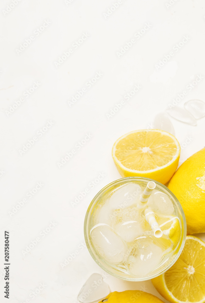 Summer refreshing drink, cold water with ice and lemon, white background, top view Summer refreshing drink, cold water with ice and lemon, white background, top view
