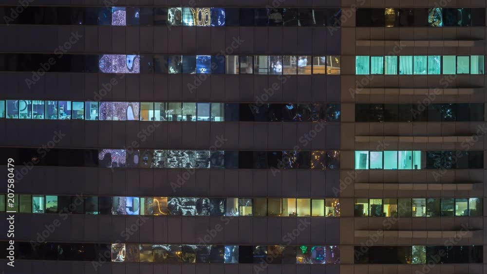 Windows of the multi-storey building of glass and steel lighting inside and moving people within timelapse Windows of the multi-storey building of glass and steel lighting inside and moving people within timelapse