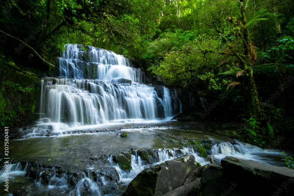 Long Exposure photography. Beautiful waterfall in the rainforest with green nature. Purakaunui Falls, The Catlins, New Zealand.